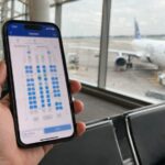 Den besten Sitzplatz im Flugzeug finden Reisender prüft am Flughafen eine Seatmap auf dem Smartphone vor dem Boarding