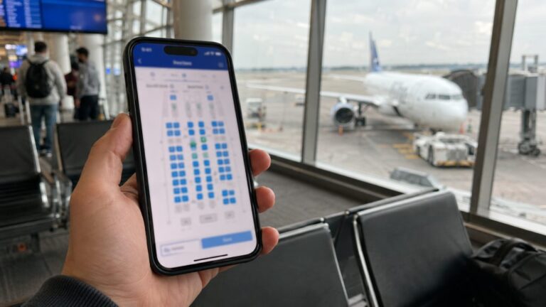Reisender prüft am Flughafen eine Seatmap auf dem Smartphone vor dem Boarding