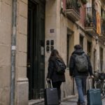 EU-Airbnb-Regeln 2026: Was Hosts wissen müssen Reisende mit Koffern vor einem europäischen Wohnhaus mit Schlüsselboxen als Symbol für Airbnb, Kurzzeitvermietung und die neuen EU-Regeln 2026